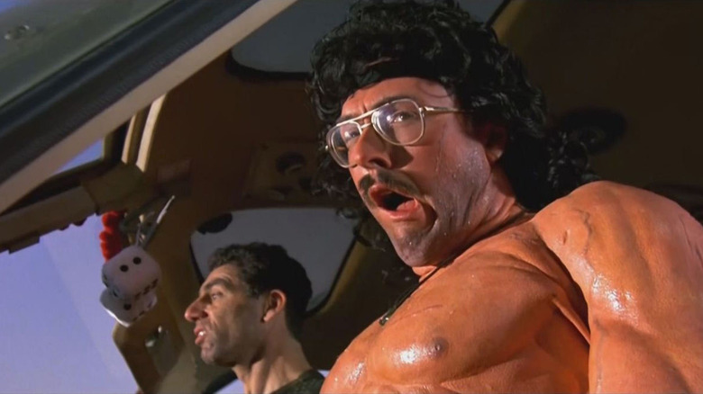 A muscular George Newman ("Weird Al" Yankovic) pilots a helicopter with Stanley Spadowski (Michael Richards) in UHF