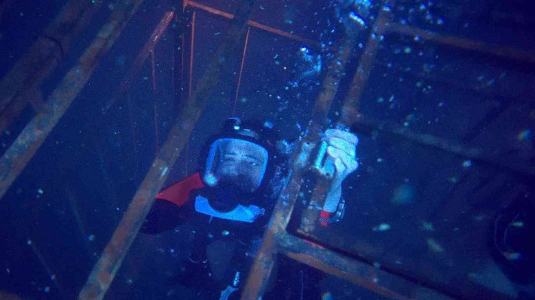 A woman trapped in a cage deep underwater