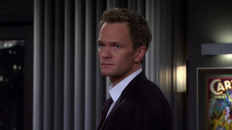Neil Patrick Harris as Barney Stinson staring off-camera in his apartment in How I Met Your Mother