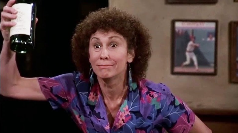 Rhea Perlman as Carla Tortelli raising a bottle in Cheers