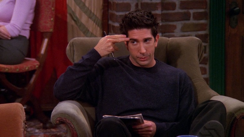 David Schwimmer as Ross Geller holding a finger gun to his head in Friends