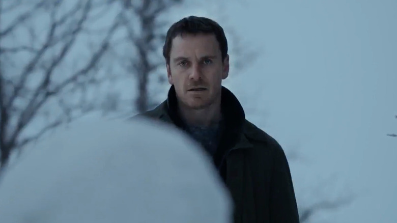 Harry Hole (Michael Fassbender) stares at a snowman in The Snowman