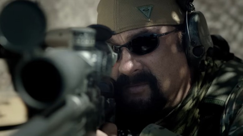 Steven Seagal as Sergeant Jacob Chandler looking into a rifle scope in Sniper: Special Ops