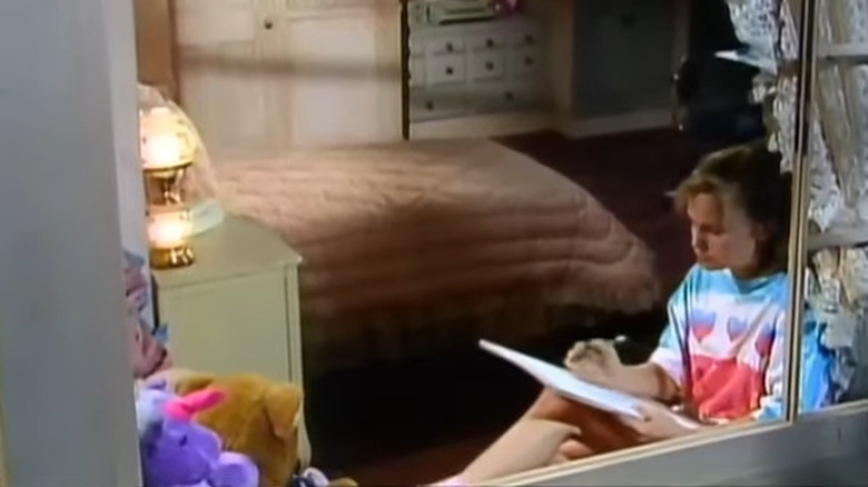 Evie (Maureen Flannigan) sitting with notebook by window in Out of This World