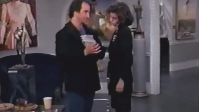 Larry (Bronson Pinchot) showing Gabriella (Courtney Cox) note in The Trouble With Larry