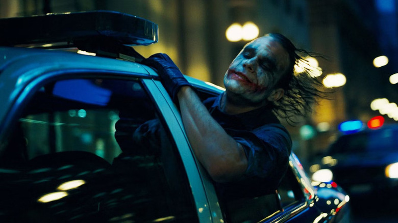 Heath Ledger as the Joker, enjoying a ride in a police car in The Dark Knight