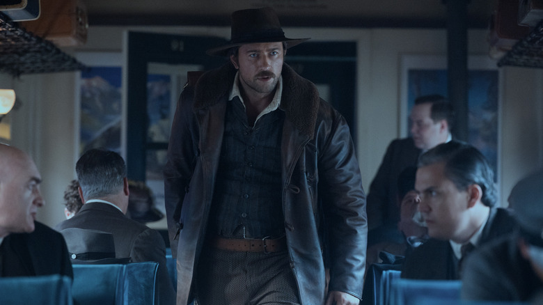Spencer Dutton walking through a train carriage