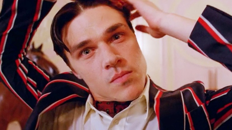 Dandy combs his hair, a wild look in his eyes