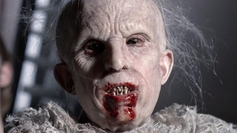 The creature bares its fangs, blood smeared around its mouth