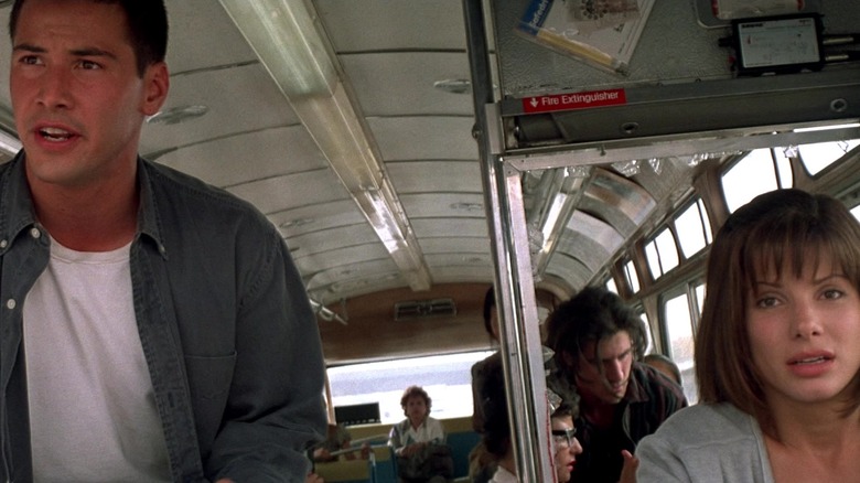 Keanu Reeves and Sandra Bullock at the front of a bus