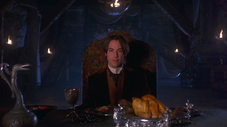 Keanu Reeves seated at table