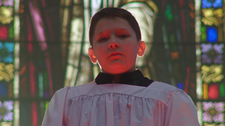 Altar boy in front of stained glass