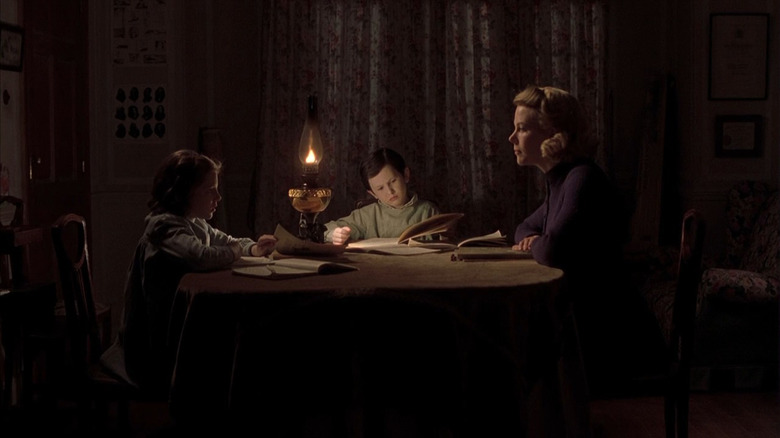 Nicole Kidman and children at a dining room table by lantern