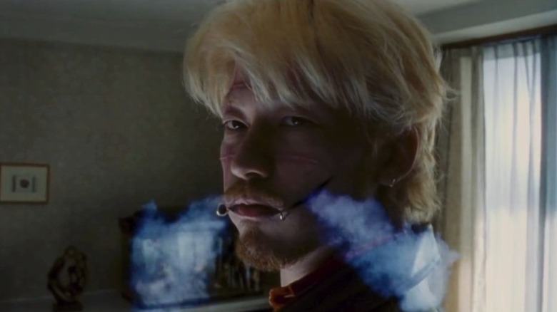 Tadanobu Asano as Kakihara with smoke exiting the cuts on his face in Ichi the Killer