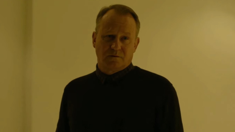 Stellan Skarsgård as Martin Vanger, standing in his home in The Girl with the Dragon Tattoo