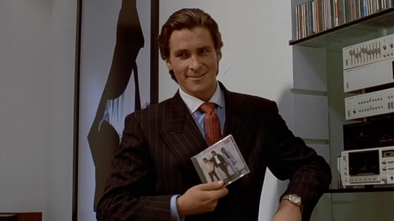 Christian Bale as Patrick Bateman holding a CD in American Psycho