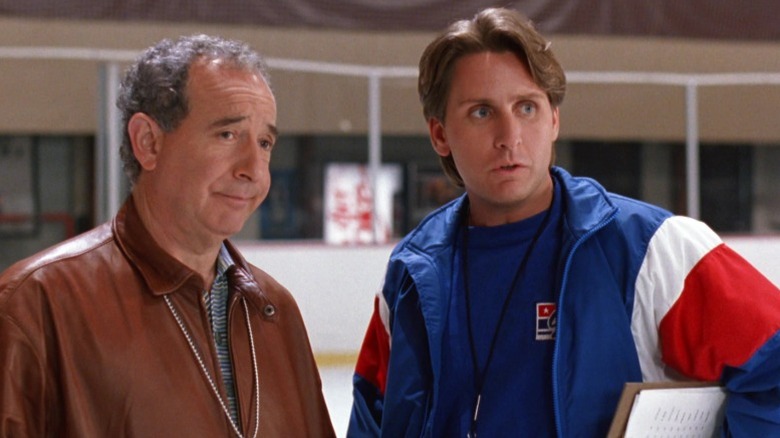 Michael Tucker as Don Tibbles standing next to Emilio Estevez as Gordon Bombay in a hockey rink in D2: The Mighty Ducks