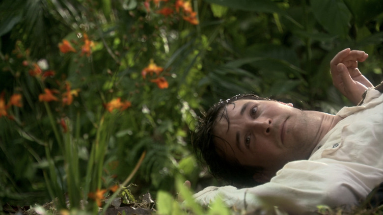 Noah Wyle as Flynn Carsen lies on the floor looking at a plant in The Librarian: Quest for the Spear