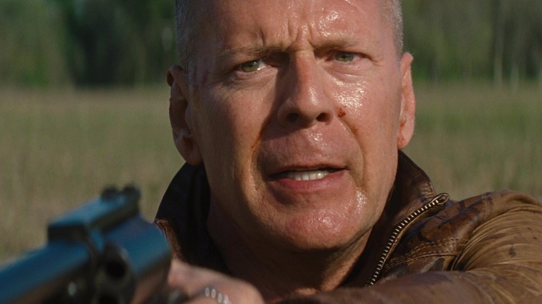 Bruce Willis as Old Joe, sweaty and holding a gun in Looper