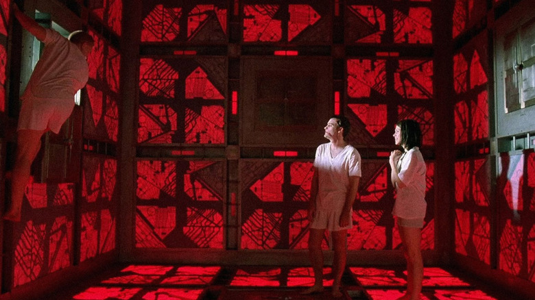Survivors stand in a geometric red industrial chamber in "Cube" (1997)
