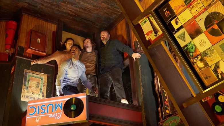 Survivors cling to the walls of an upside-down pool hall in "Escape Room" (2019)