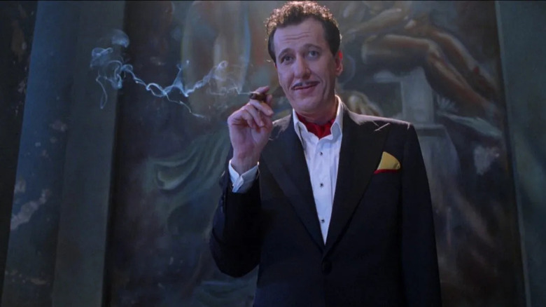 Stephen H. Price (Geoffrey Rush) smokes a cigar and grins in "House on Haunted Hill" (1999)