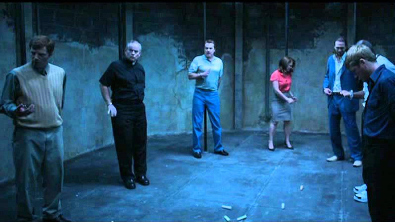 Several captives are handcuffed to pipes in a strange room, in "Nine Dead" (2009)