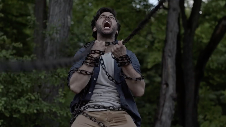 Michael (Mark Ghanimé) wails in heavy chains, in "No Escape Room" (2018)