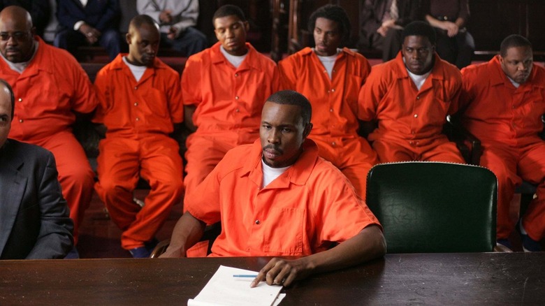 Avon Barksdale in orange prison fatigues sitting before a group of other prisoners in The Wire