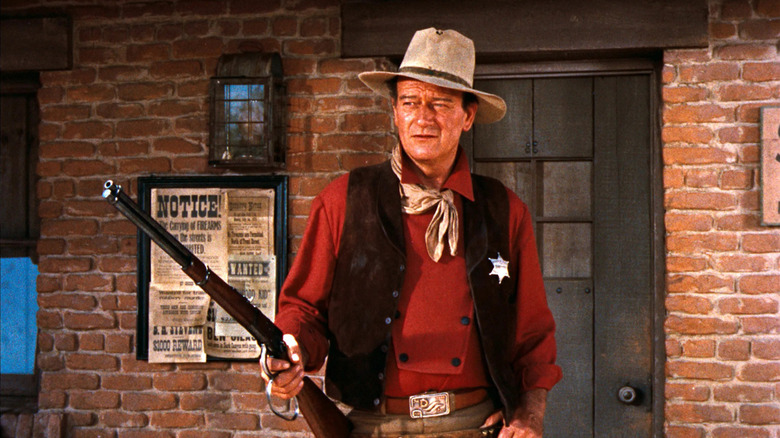 John Wayne as Sheriff John T. Chance holding a rifle in Rio Bravo