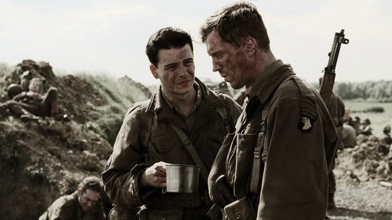 With a cup in hand, Roe says something to a despondent-looking Major Winters in Band of Brothers