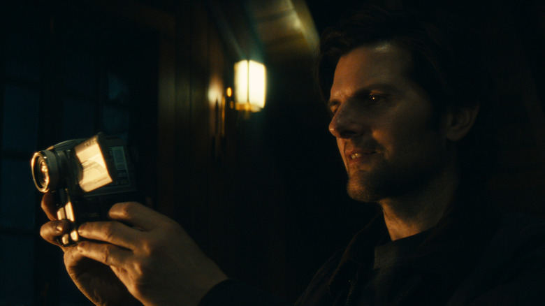Adam Scott's Mark Scout holding a video camera on Severance