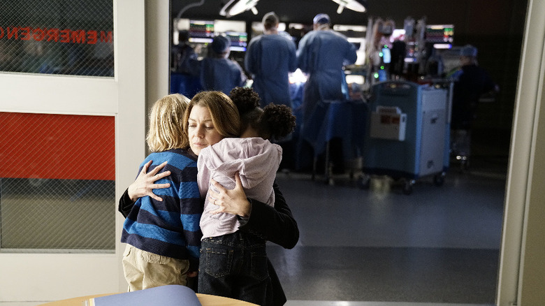 Meredith hugging Bailey and Zola outside of an operating room on Grey's Anatomy