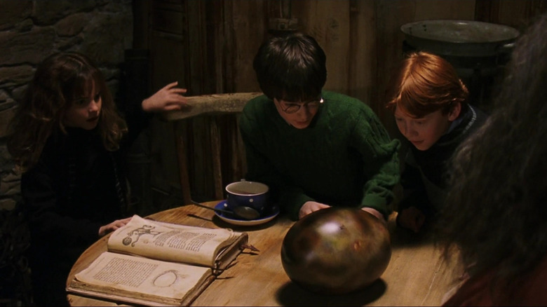Hermione Harry and Ron inspecting a dragon egg in Harry Potter and the Sorcerer's Stone