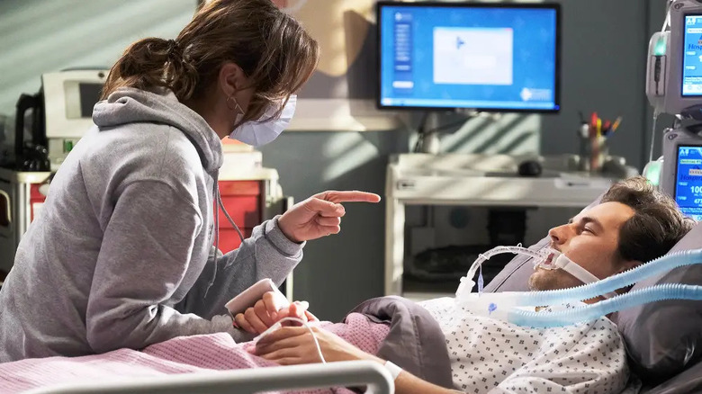 Meredith (Ellen Pompeo) wearing a mask talking to an unconscious Dr. Andrew DeLuca (Giacomo Gianniotti) on Grey's Anatomy