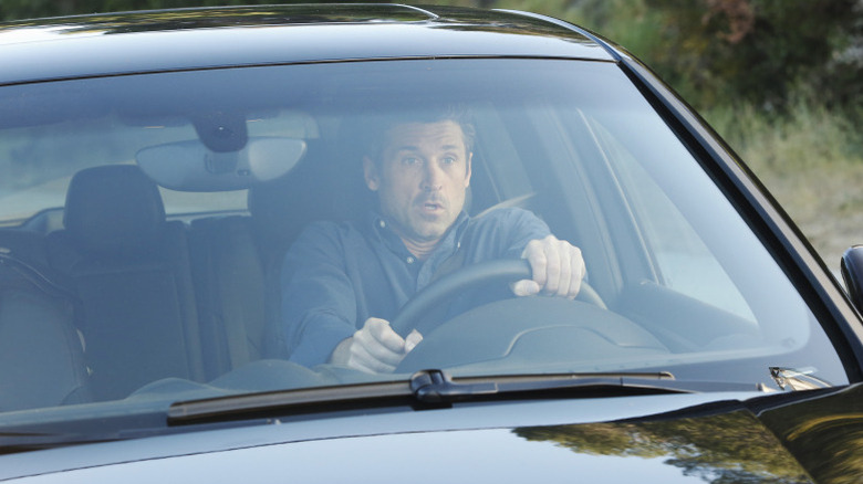 Derek (Patrick Dempsey) driving his car looking surprised by something on Grey's Anatomy