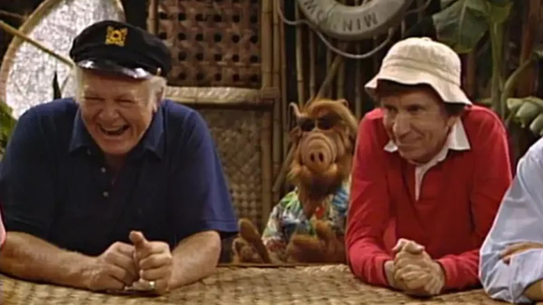 The Skipper and Gilligan at a table, with ALF behind them