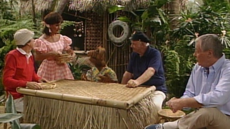 Gilligan, Mary Ann, ALF, the Skipper, and the Professor all gathered around a table