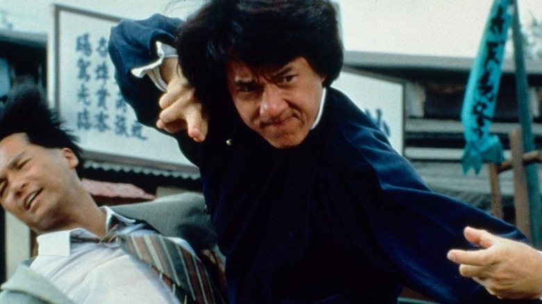 Jackie Chan taking cover with a gun