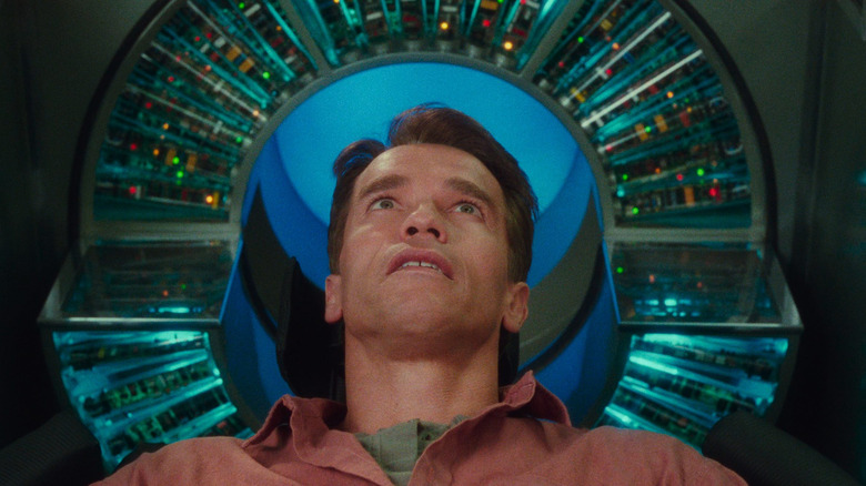 Arnold Schwarzenegger leaning back into the Recall machine