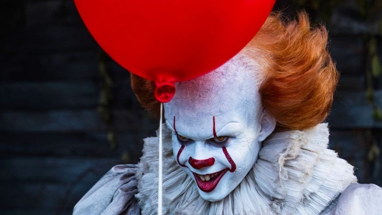 Pennywise holds
        balloon in It