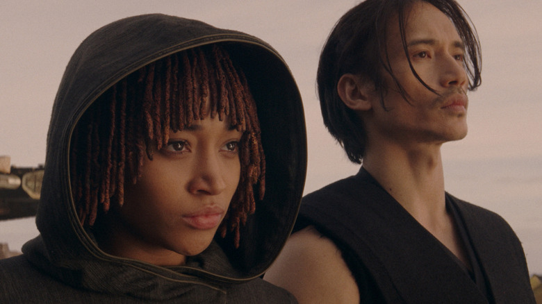 Osha and Qimir standing next to each other under a romantic sunset at the end of Star Wars: The Acolyte