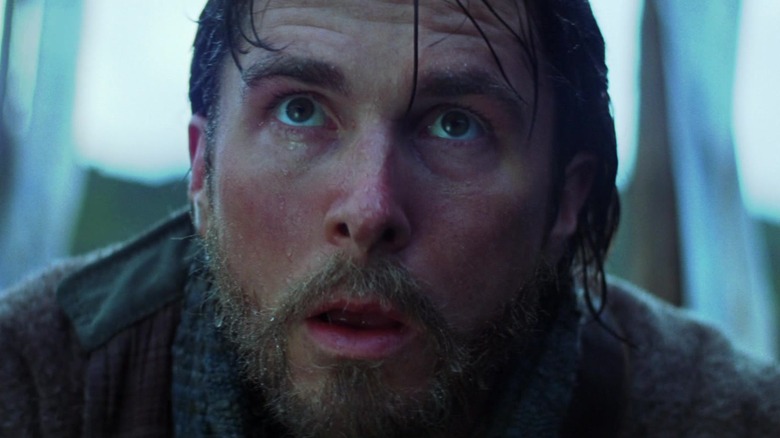 Bruce Wayne staring up in surprise in Batman Begins