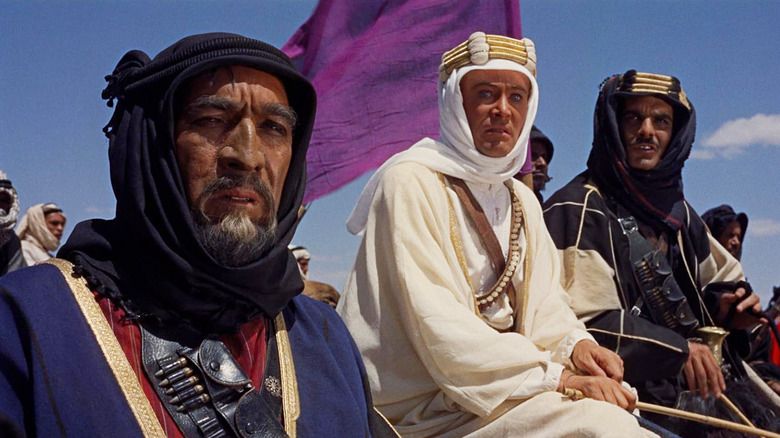 Anthony Quinn como Auda Abu Tayi, Peter O'Toole como TE Lawrence e Omar Sharif como Sherif Ali ibn el Kharish viajando no deserto em Lawrence da Arábia