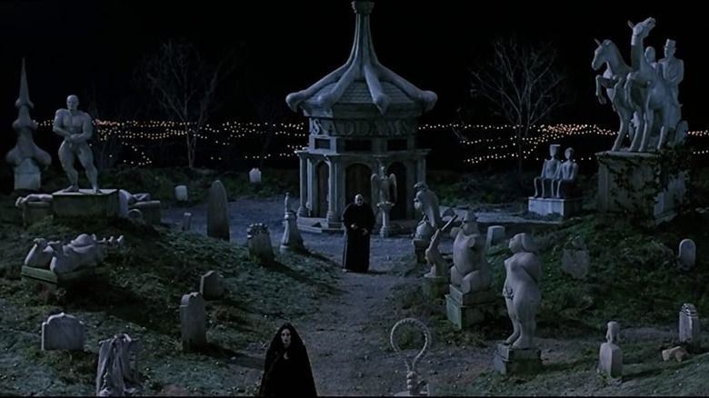 Morticia and Fester Addams walk in family cemetery