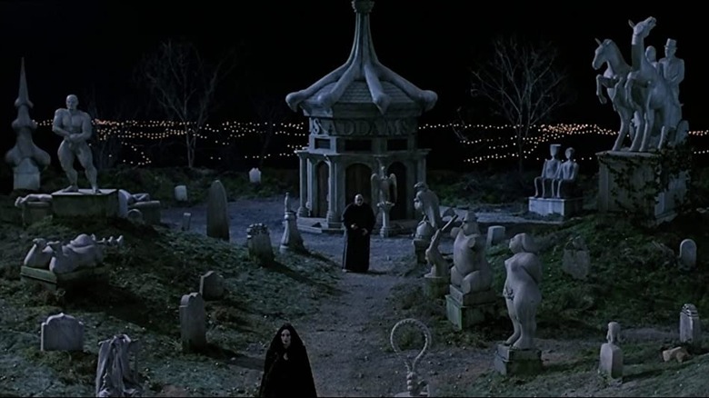 Morticia and Fester Addams walk in family cemetery