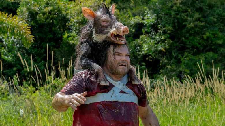 Jack Black as Doug with a boar taped to his back in Anaconda (2025)