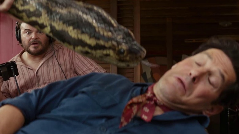 Paul Rudd as Griff avoiding the snake while filming a scene as Jake Black as Doug directs in the background in Anaconda (2025)