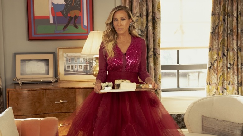 Carrie in a big skirt holding a cheese plate on And Just Like That...