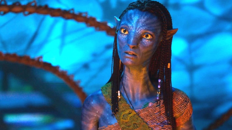 Zoe Saldana as Neytiri with her head cocked to the side in Avatar: Fire and Ash
